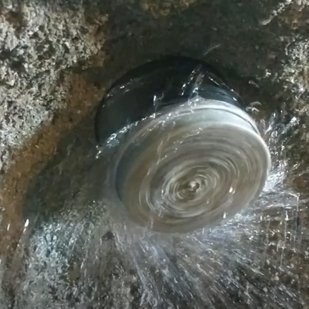 Diamond Core Drill Coming Through A Concrete Wall