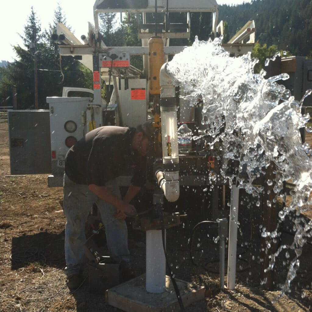 Man Working On Well Head Releasing Water